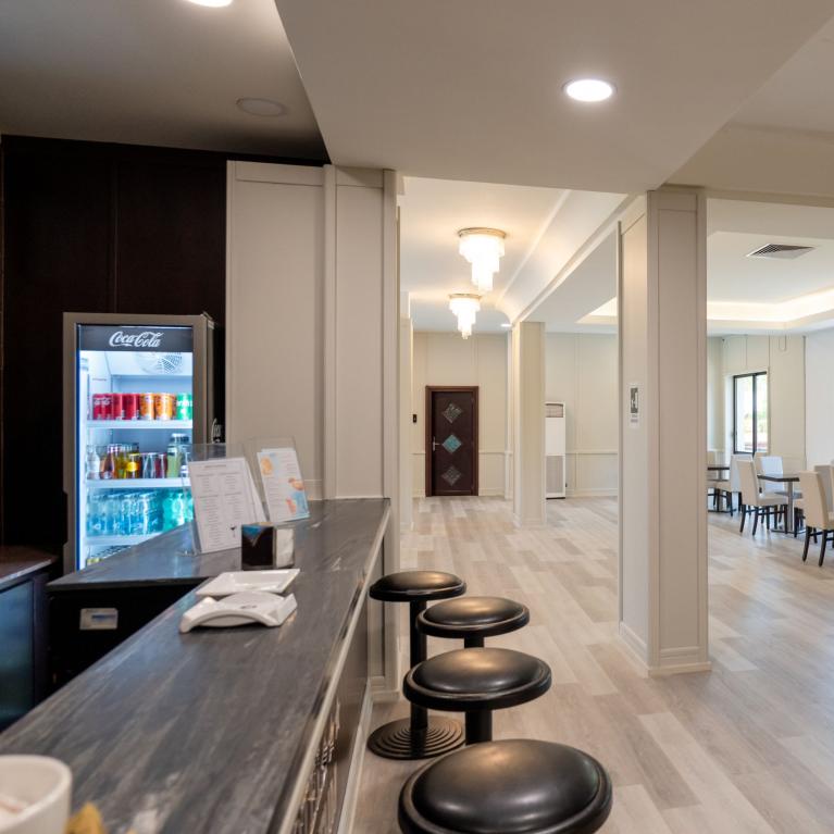 Elegant cafe room with white chairs, light flooring, and a welcoming atmosphere.