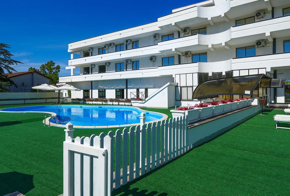 Outdoor pool with umbrellas, bright sun, and a relaxing atmosphere.